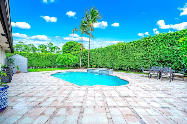 view of swimming pool with a storage shed, an outdoor structure, a pool with connected hot tub, outdoor dining space, and a patio area