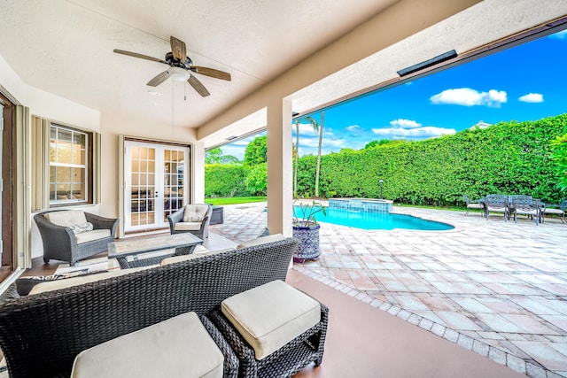 view of patio featuring ceiling fan, a pool with connected hot tub, an outdoor living space, and french doors