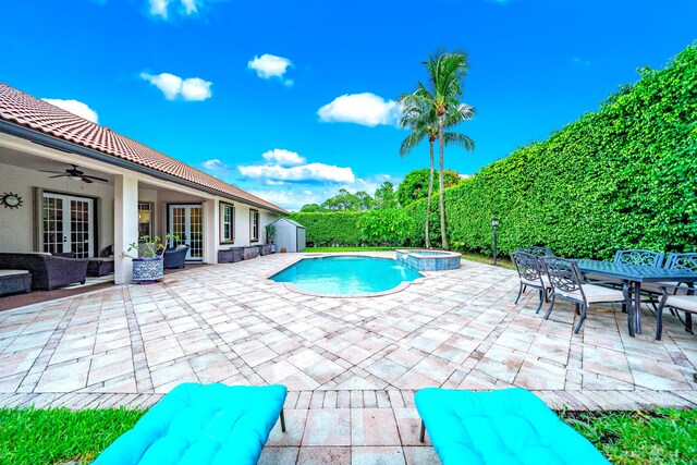 view of pool with ceiling fan, french doors, a storage shed, a patio area, and an in ground hot tub