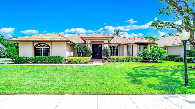 mediterranean / spanish home with a front lawn