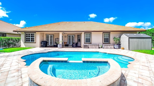 view of pool with french doors, a storage unit, a patio area, an in ground hot tub, and area for grilling