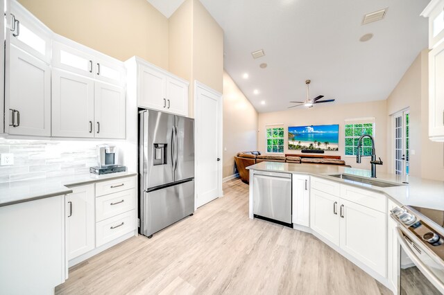 kitchen featuring sink, kitchen peninsula, ceiling fan, white cabinetry, and stainless steel appliances