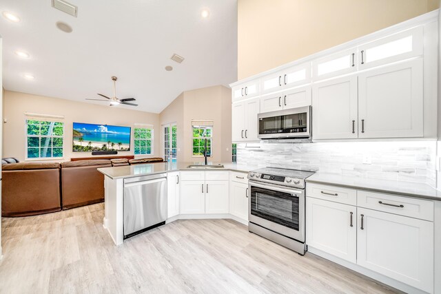 kitchen featuring white cabinets, appliances with stainless steel finishes, and kitchen peninsula