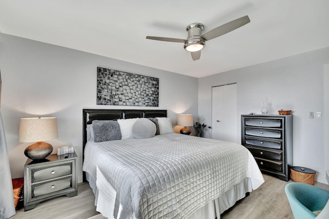 bedroom featuring ceiling fan, light wood-type flooring, and a closet