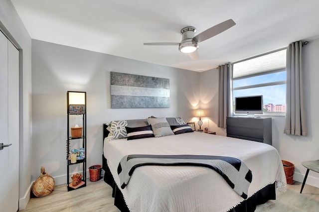 bedroom with light hardwood / wood-style floors, ceiling fan, and a closet