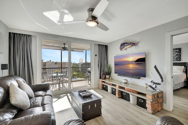 living room featuring ceiling fan and light wood-type flooring