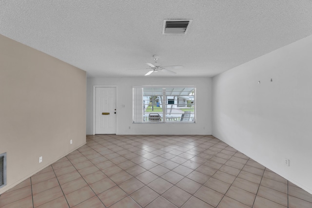 tiled empty room featuring ceiling fan and a textured ceiling