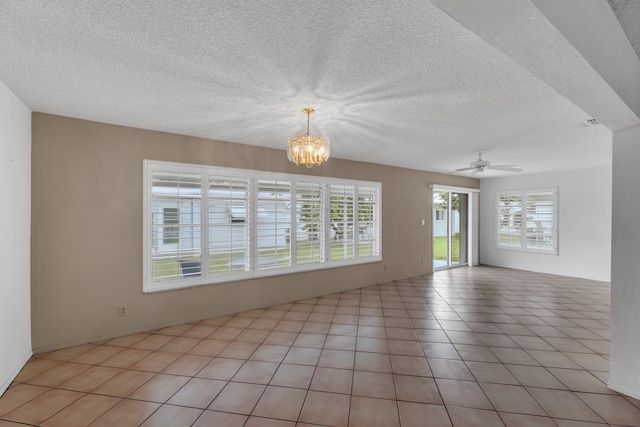 unfurnished room with ceiling fan with notable chandelier, a textured ceiling, and light tile patterned flooring