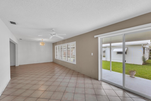 spare room with ceiling fan, a textured ceiling, and light tile patterned flooring