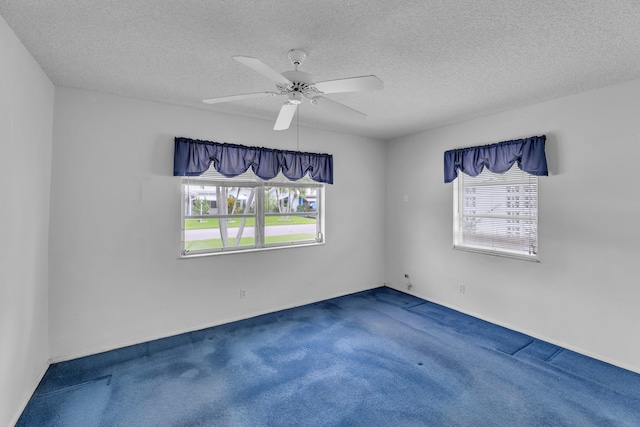 carpeted empty room with ceiling fan and a textured ceiling