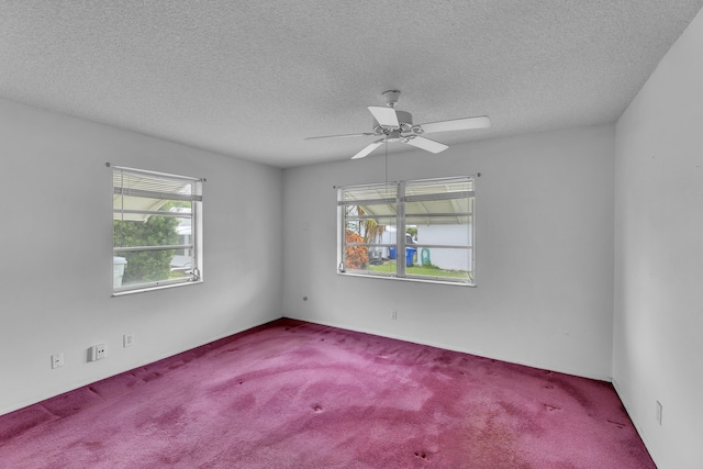 carpeted spare room featuring a textured ceiling and ceiling fan