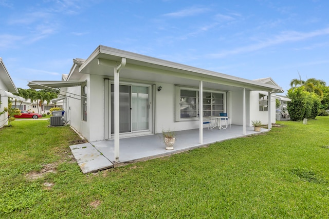 back of property featuring a lawn and central AC unit