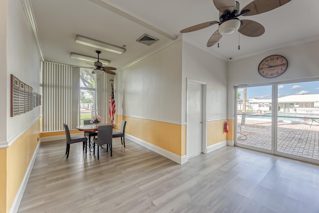 dining space with light wood-type flooring, crown molding, and ceiling fan