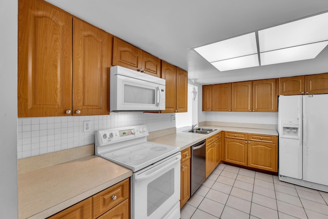 kitchen with white appliances, sink, light tile patterned floors, and tasteful backsplash