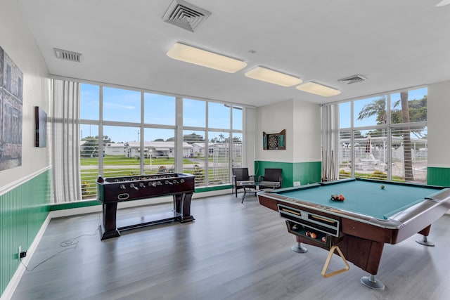 game room with a wall of windows, hardwood / wood-style flooring, and billiards