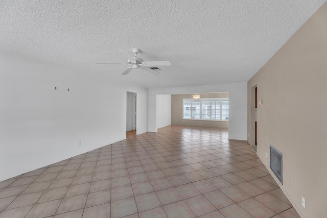 tiled empty room featuring a textured ceiling and ceiling fan