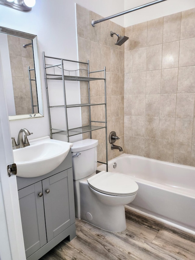 full bathroom featuring wood-type flooring, vanity, toilet, and tiled shower / bath