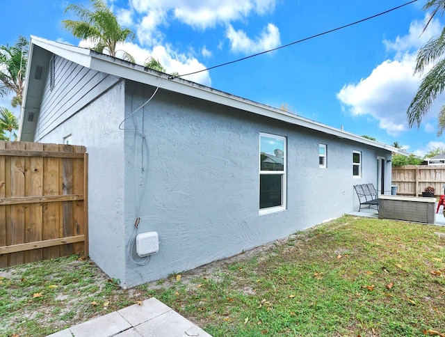 view of property exterior with a yard and a patio area