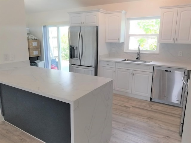 kitchen with stainless steel appliances, white cabinets, sink, and kitchen peninsula