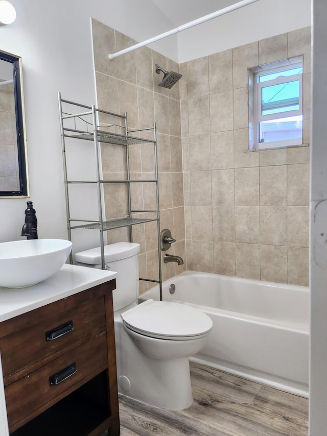 full bathroom with toilet, tiled shower / bath combo, vanity, and hardwood / wood-style floors