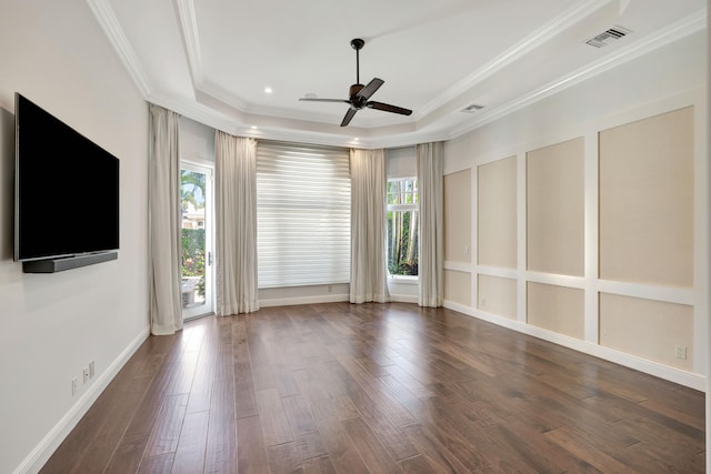 empty room featuring a tray ceiling, crown molding, dark hardwood / wood-style flooring, and ceiling fan