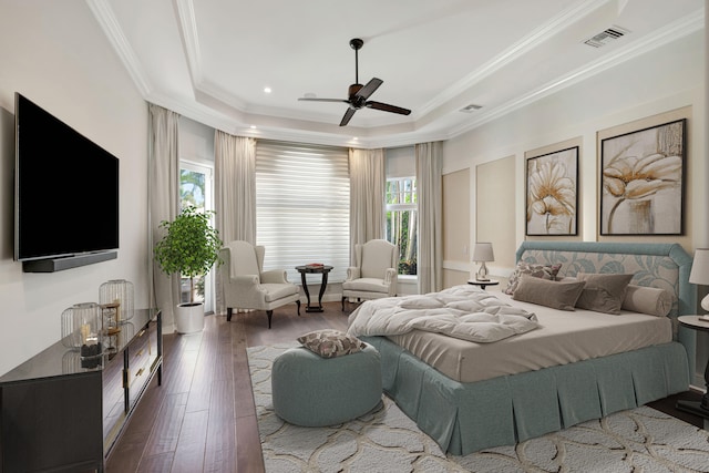 bedroom featuring a tray ceiling, dark hardwood / wood-style floors, ornamental molding, and ceiling fan