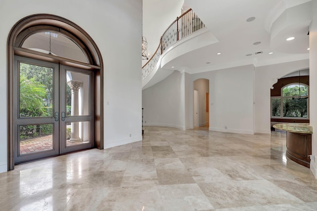 tiled entrance foyer featuring crown molding and french doors