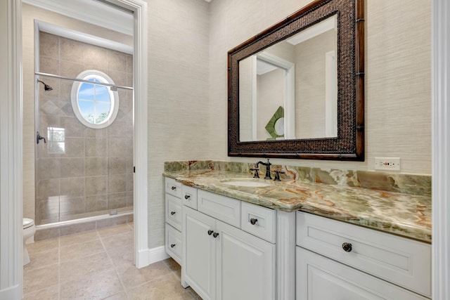 bathroom featuring vanity, toilet, a tile shower, and tile patterned floors