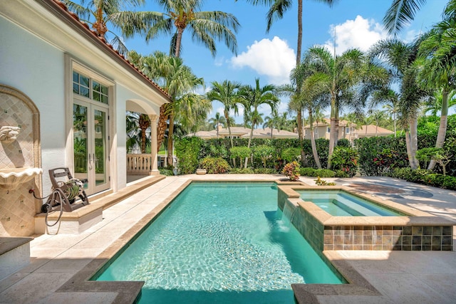 view of swimming pool featuring an in ground hot tub, french doors, and a patio area