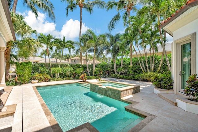 view of pool featuring a patio and an in ground hot tub