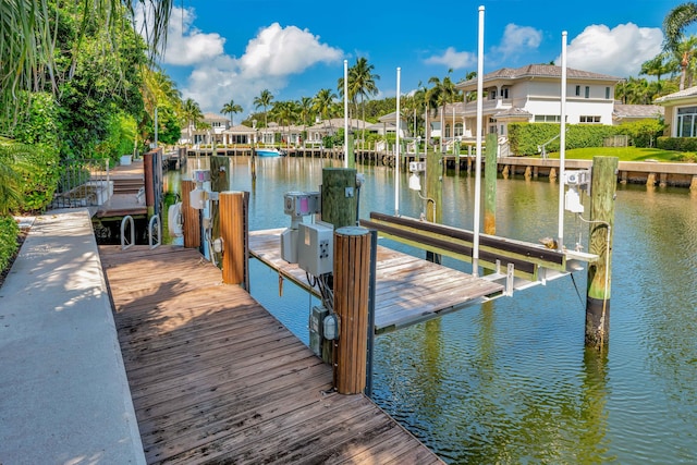 view of dock with a water view, a residential view, and boat lift