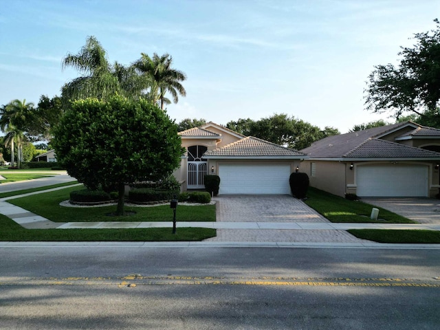 view of front of property with a garage and a front lawn