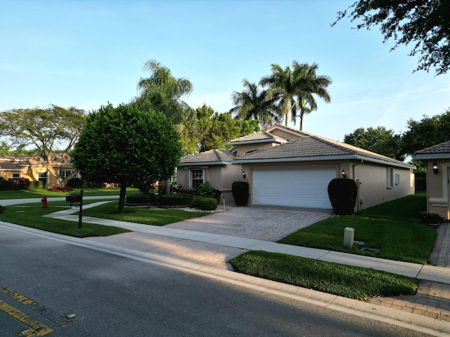 view of front of home with a garage and a front lawn