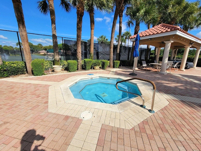 view of swimming pool featuring a hot tub, a gazebo, and a patio