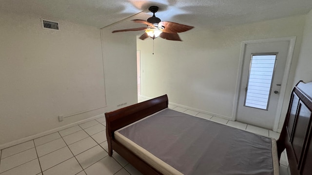 unfurnished bedroom with ceiling fan, a textured ceiling, and light tile patterned floors