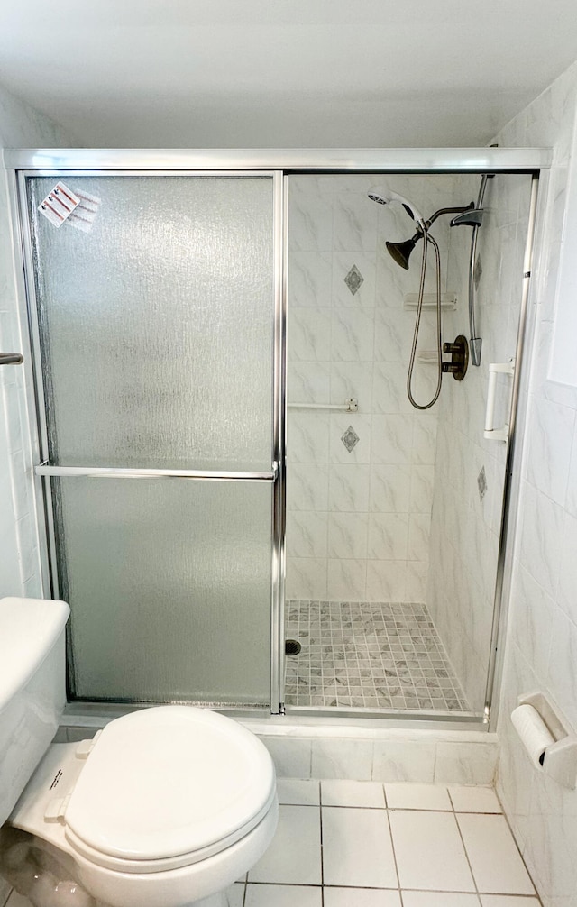 bathroom with tile patterned floors, toilet, and an enclosed shower