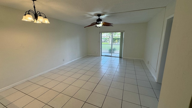 tiled spare room with a textured ceiling and ceiling fan with notable chandelier