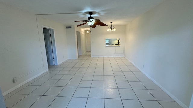 unfurnished room featuring ceiling fan with notable chandelier and light tile patterned flooring