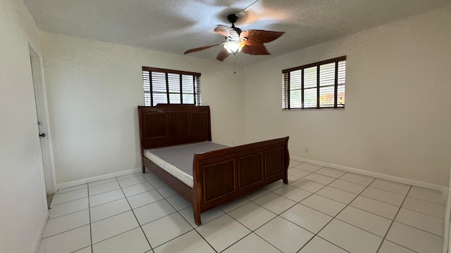 unfurnished bedroom featuring a textured ceiling, ceiling fan, and light tile patterned flooring