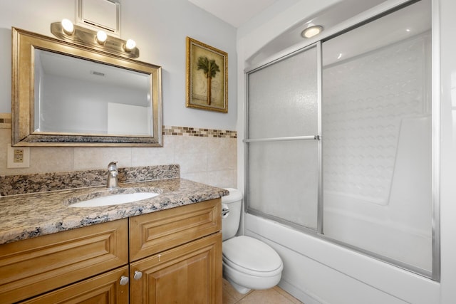 full bathroom featuring tile walls, tile patterned flooring, vanity, combined bath / shower with glass door, and toilet