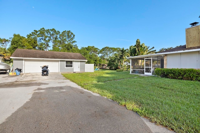 view of yard with a garage and a sunroom