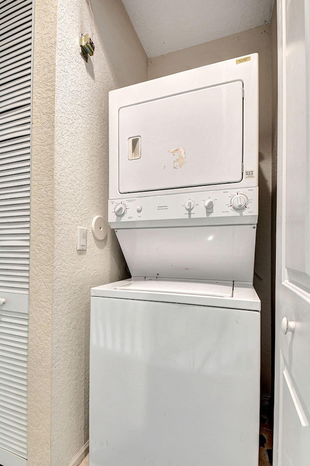 clothes washing area with stacked washer / dryer