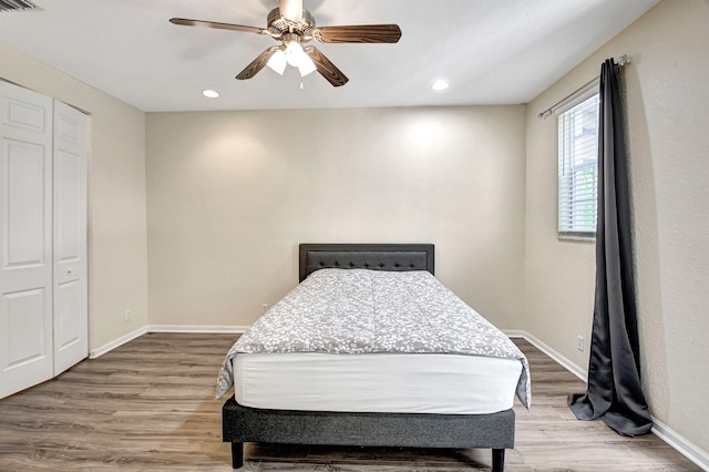 bedroom with ceiling fan, wood-type flooring, and a closet