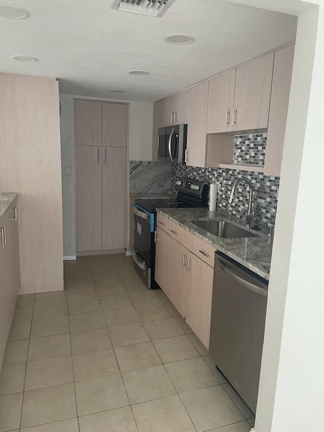 kitchen with sink, stainless steel appliances, light brown cabinets, and backsplash