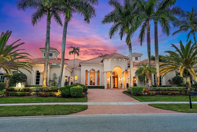 mediterranean / spanish house featuring french doors and a lawn