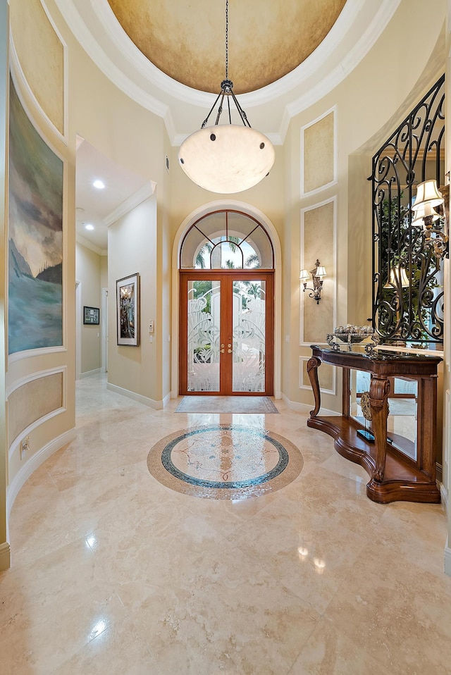 entryway featuring light tile patterned flooring, a raised ceiling, a towering ceiling, and french doors