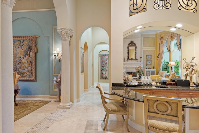 interior space featuring decorative columns, tile patterned floors, and vanity