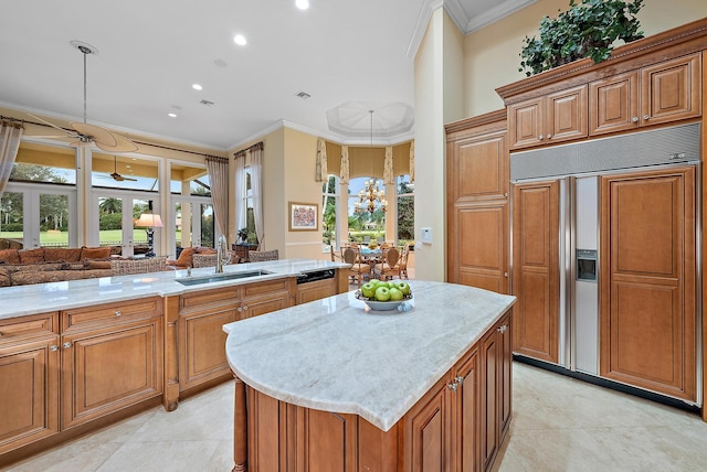 kitchen featuring sink, ornamental molding, paneled built in fridge, and light tile patterned floors