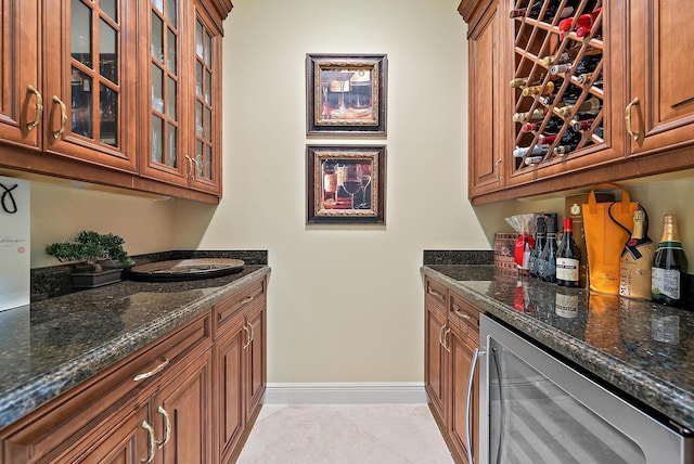 kitchen with light tile patterned flooring, wine cooler, and dark stone counters