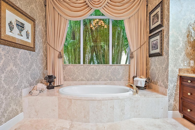 bathroom featuring a relaxing tiled tub and vanity